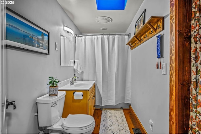 bathroom with wood finished floors, toilet, a shower with shower curtain, and vanity