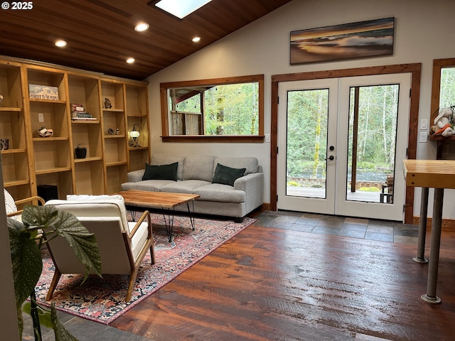 living room featuring recessed lighting, vaulted ceiling with skylight, french doors, and plenty of natural light