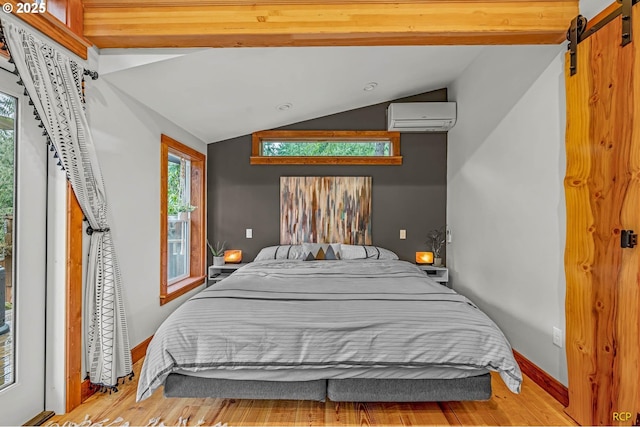 bedroom with vaulted ceiling, multiple windows, a wall mounted AC, and wood finished floors