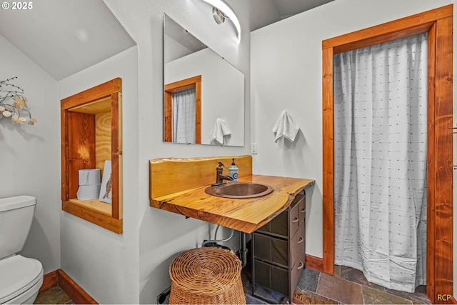 full bathroom featuring toilet, baseboards, and a sink