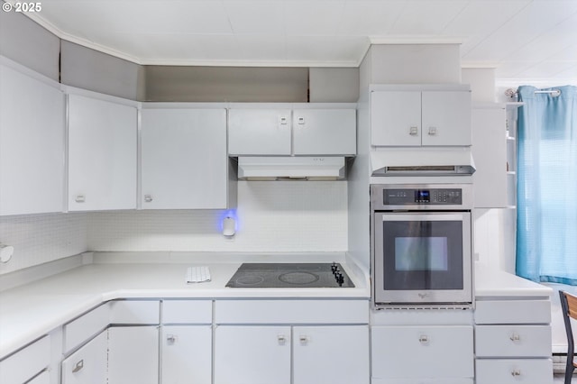 kitchen with oven, under cabinet range hood, light countertops, white cabinetry, and black electric cooktop