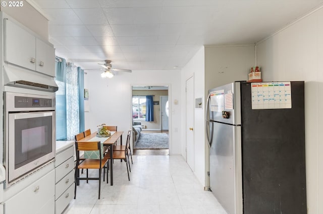 kitchen with appliances with stainless steel finishes, a ceiling fan, and white cabinetry