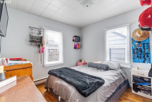 bedroom featuring a baseboard radiator and wood finished floors