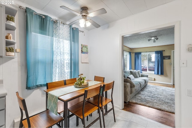 dining space with light tile patterned floors, a textured ceiling, and a ceiling fan