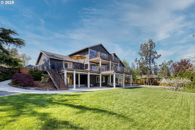 back of property featuring a wooden deck, a patio area, fence, a yard, and stairs