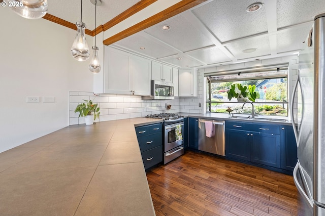 kitchen with white cabinets, backsplash, appliances with stainless steel finishes, and blue cabinets
