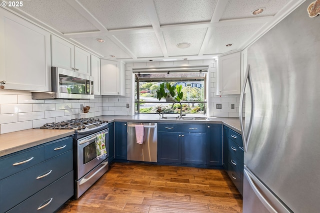 kitchen featuring a sink, appliances with stainless steel finishes, dark wood-style flooring, and blue cabinetry