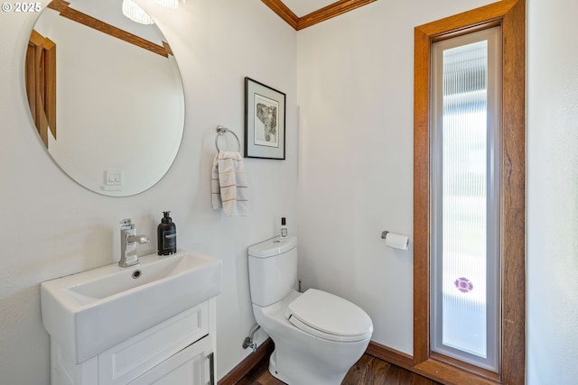 bathroom featuring wood finished floors, vanity, baseboards, toilet, and ornamental molding