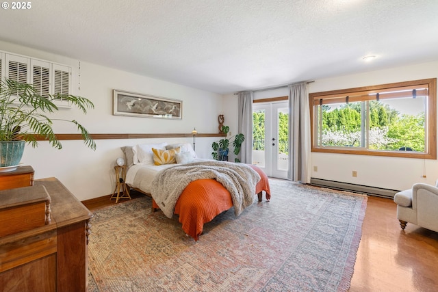bedroom featuring a baseboard radiator, a textured ceiling, and access to exterior