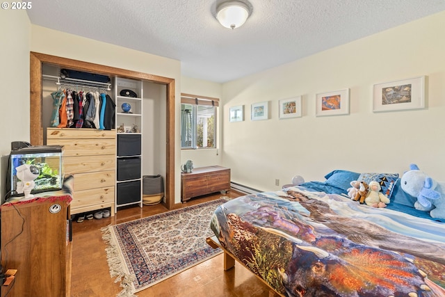 bedroom featuring a closet, a baseboard radiator, and a textured ceiling