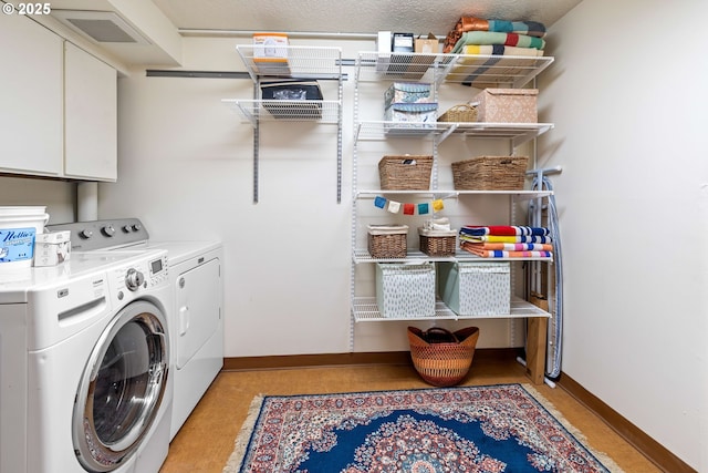 laundry room with visible vents, baseboards, cabinet space, and washing machine and dryer