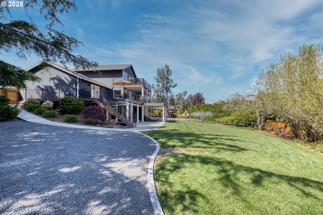 exterior space featuring stairs, a deck, and a front lawn