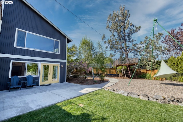 view of yard with fence, a playground, a patio area, and french doors