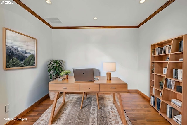 home office with baseboards, ornamental molding, wood finished floors, and visible vents