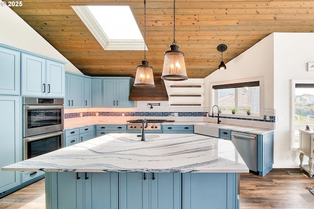 535 SW Cardinal St, Depoe Bay, OR 97341 - kitchen featuring stainless steel appliances, blue cabinets, a skylight, lofted ceiling, and wood ceiling