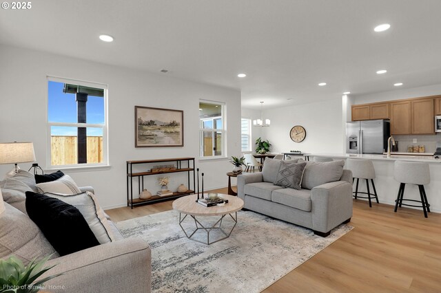 1033 Sommerville Loop, Harrisburg, OR 97446 - living area featuring light wood-style flooring, recessed lighting, a chandelier, and baseboards