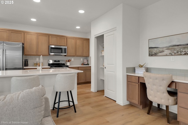 1033 Sommerville Loop, Harrisburg, OR 97446 - kitchen with stainless steel appliances, decorative backsplash, light countertops, a breakfast bar, and recessed lighting