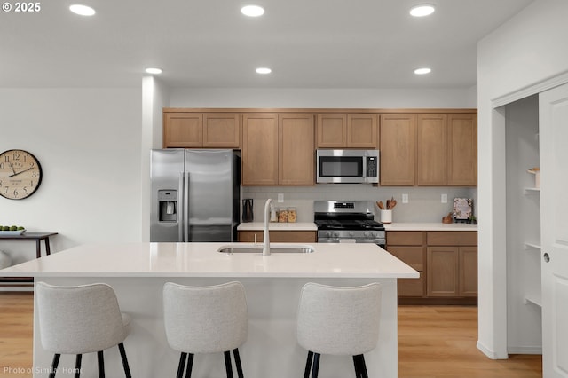 1033 Sommerville Loop, Harrisburg, OR 97446 - kitchen featuring stainless steel appliances, a sink, a breakfast bar, decorative backsplash, and recessed lighting