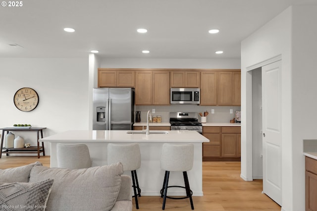 1033 Sommerville Loop, Harrisburg, OR 97446 - kitchen with appliances with stainless steel finishes, light wood-type flooring, a sink, light countertops, and open floor plan