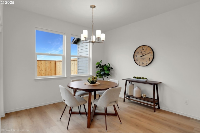 1033 Sommerville Loop, Harrisburg, OR 97446 - dining room featuring a chandelier, light wood-type flooring, and baseboards