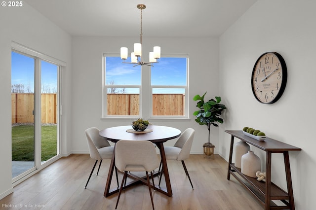 1033 Sommerville Loop, Harrisburg, OR 97446 - dining area with a chandelier, light wood-style flooring, and baseboards