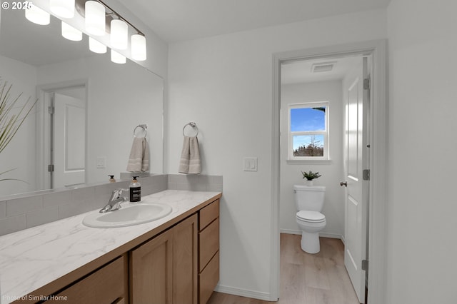 1033 Sommerville Loop, Harrisburg, OR 97446 - bathroom featuring vanity, wood finished floors, toilet, and baseboards