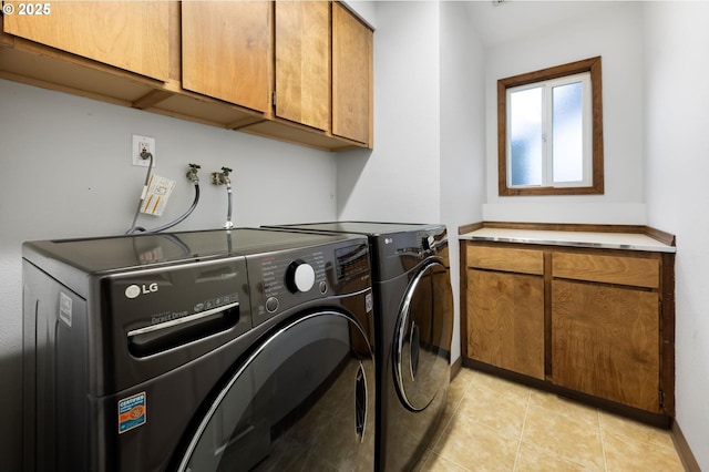 laundry room with washing machine and dryer, cabinet space, baseboards, and light tile patterned floors