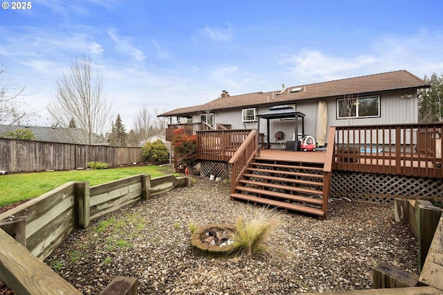 back of property featuring a fenced backyard, a lawn, a deck, and a gazebo