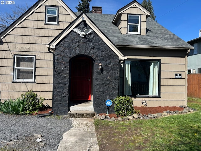 1910 E 33rd St, Vancouver, WA 98663 - view of front of house featuring a chimney, fence, stone siding, and roof with shingles