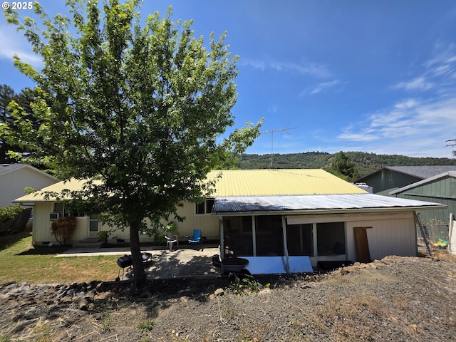4545 Ridenour St, Roseburg, OR 97470 - back of property featuring a sunroom, a metal roof, and a patio