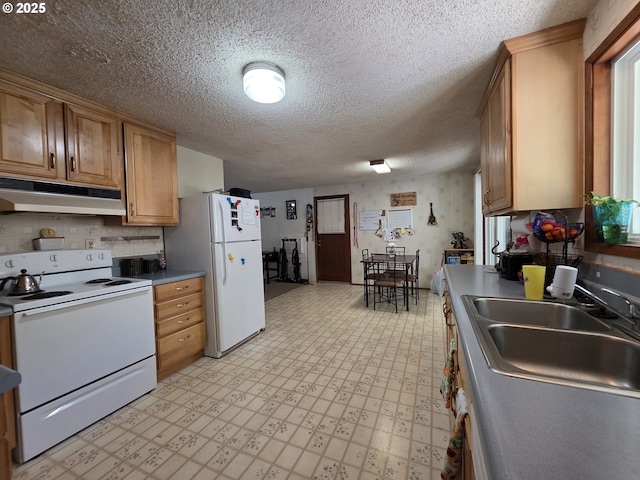 4545 Ridenour St, Roseburg, OR 97470 - kitchen featuring white appliances, under cabinet range hood, light flooring, a textured ceiling, and brown cabinetry