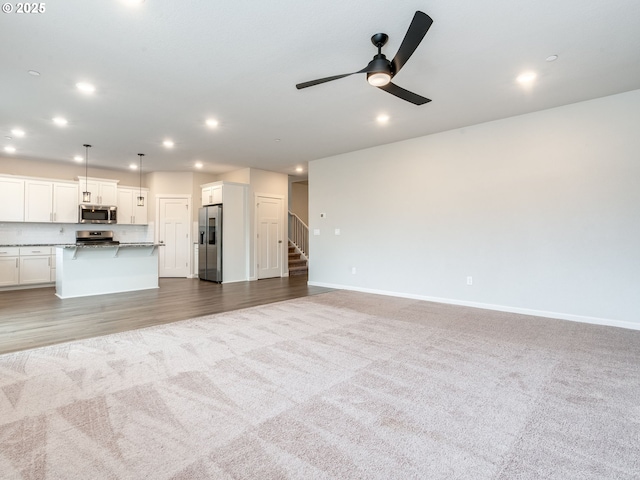6820 N 89th Loop, Camas, WA 98607 - unfurnished living room with carpet, recessed lighting, stairs, and a ceiling fan