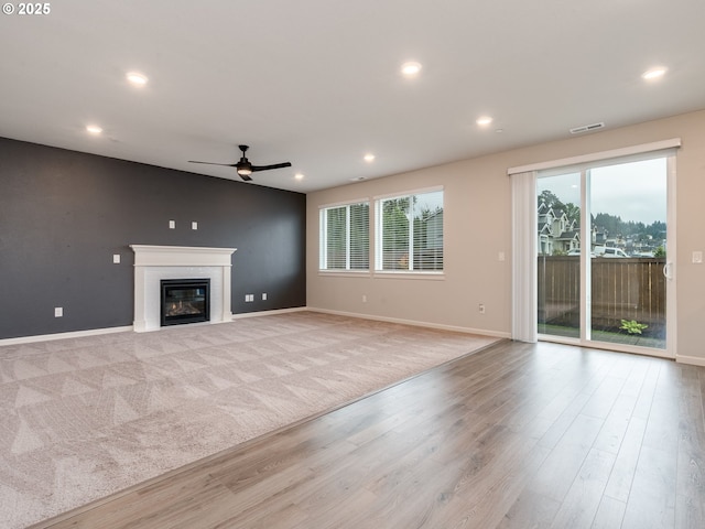 6820 N 89th Loop, Camas, WA 98607 - unfurnished living room featuring a ceiling fan, recessed lighting, a glass covered fireplace, and wood finished floors