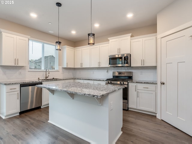 6820 N 89th Loop, Camas, WA 98607 - kitchen featuring stainless steel appliances, white cabinets, tasteful backsplash, a breakfast bar, and recessed lighting