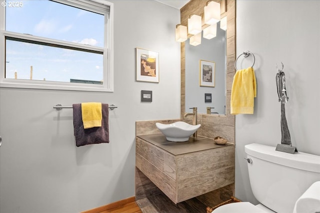 bathroom with vanity, toilet, and wood finished floors