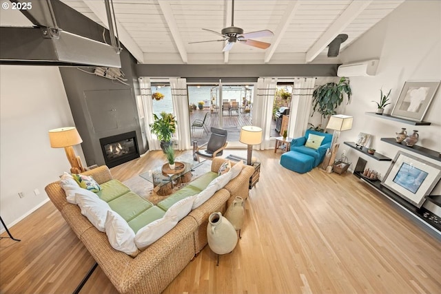 living area with wooden ceiling, a glass covered fireplace, a wall unit AC, and wood finished floors
