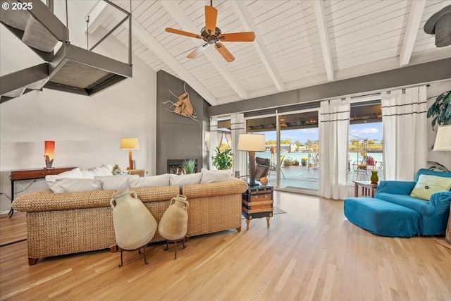 living room with beamed ceiling, high vaulted ceiling, a healthy amount of sunlight, and wood finished floors