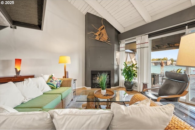living area featuring wood finished floors, a healthy amount of sunlight, wooden ceiling, and beamed ceiling