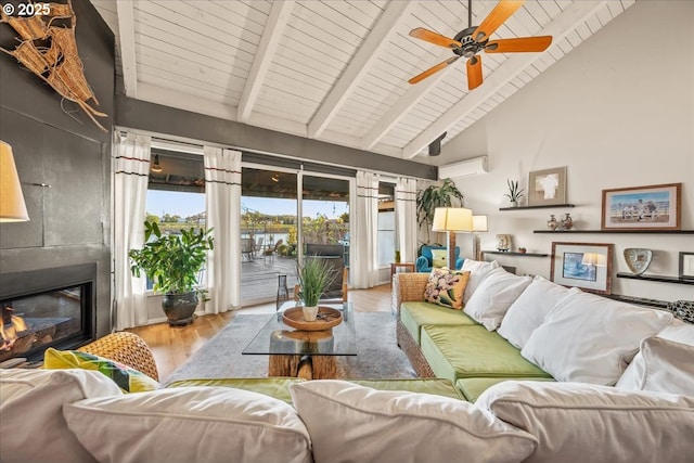 living room featuring ceiling fan, a fireplace, wood finished floors, beamed ceiling, and a wall mounted AC