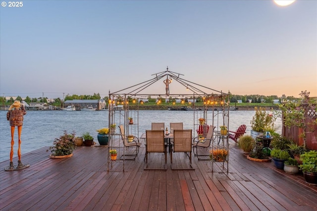 view of dock with a water view, a gazebo, and outdoor dining area