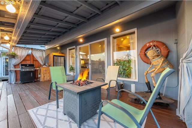 wooden terrace featuring an outdoor fire pit and area for grilling