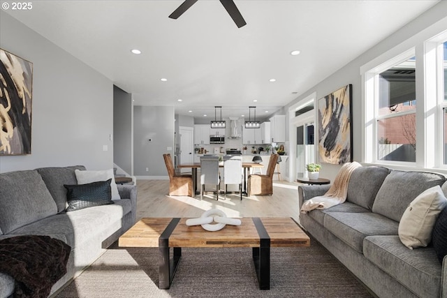 living room featuring light wood-type flooring and ceiling fan