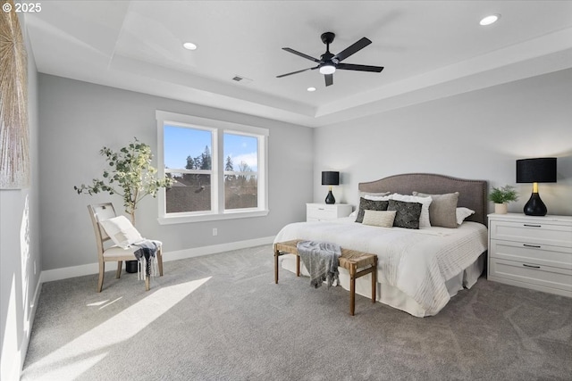 bedroom with ceiling fan, a raised ceiling, and carpet flooring