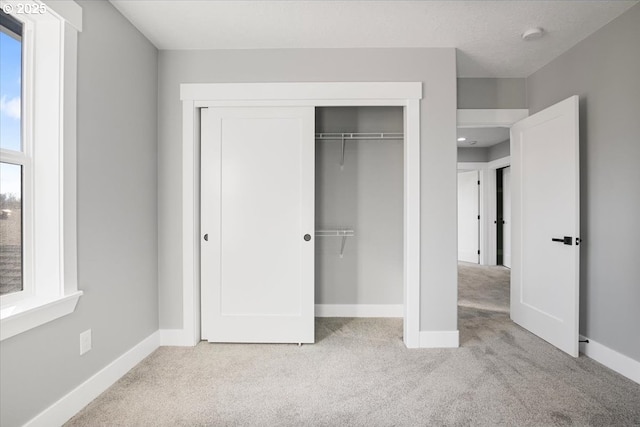 unfurnished bedroom featuring a closet and light carpet