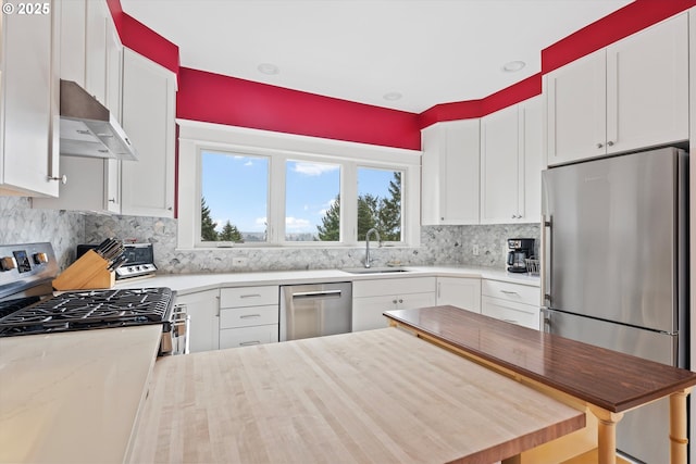 kitchen with white cabinetry, sink, wooden counters, decorative backsplash, and stainless steel appliances