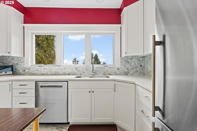 kitchen featuring white cabinetry, appliances with stainless steel finishes, sink, and a wealth of natural light