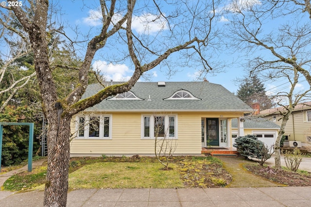 view of front of property with a garage and a front lawn