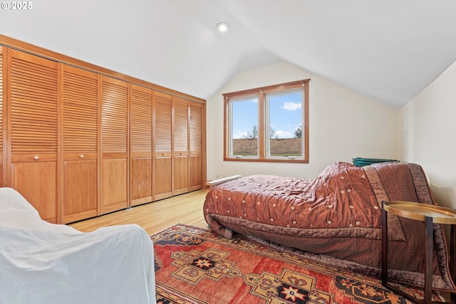 bedroom with vaulted ceiling and light wood-type flooring