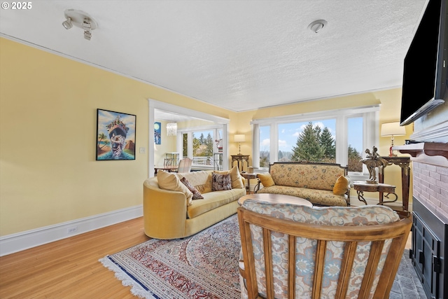 living room with hardwood / wood-style floors, a textured ceiling, and a fireplace