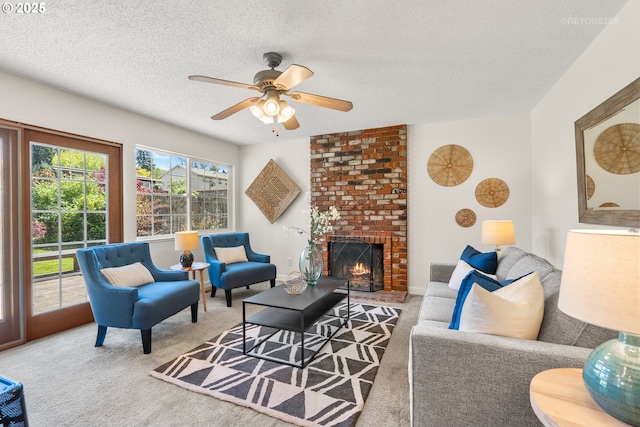 living area featuring a ceiling fan, carpet flooring, a textured ceiling, and a fireplace
